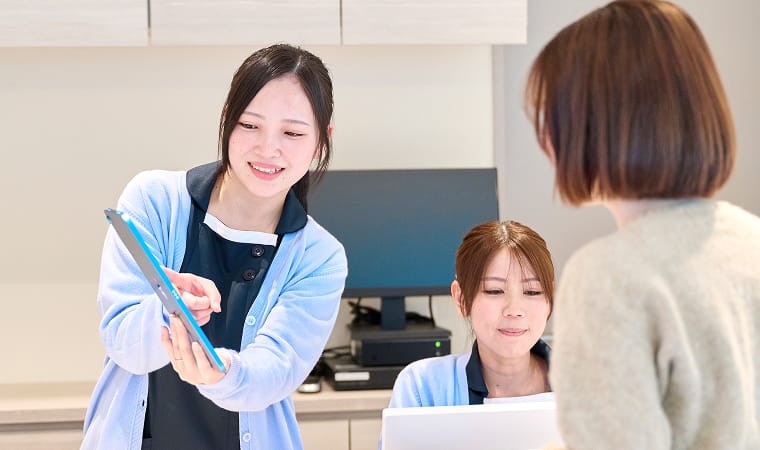 受付で患者さんに説明している様子